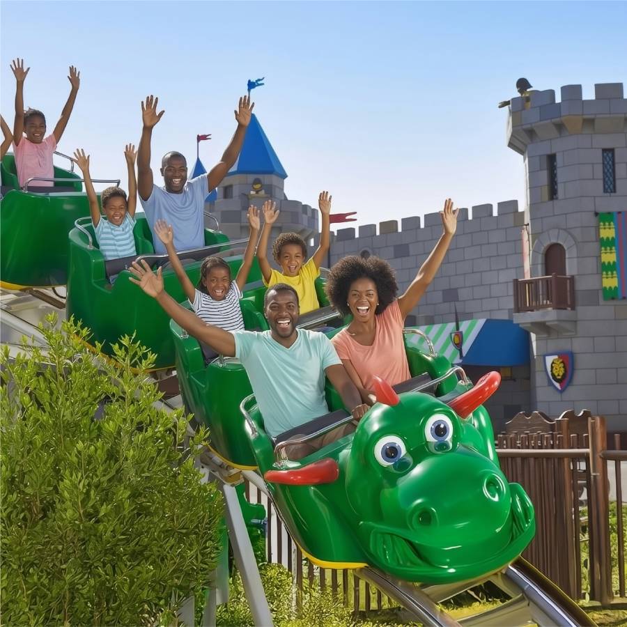 Family enjoying a dragon-themed roller coaster ride at a theme park.
