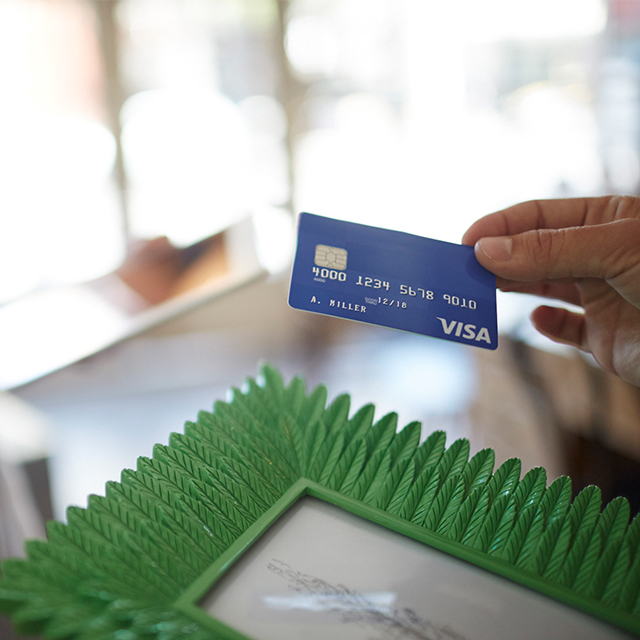 Person presenting Visa chip card as payment.